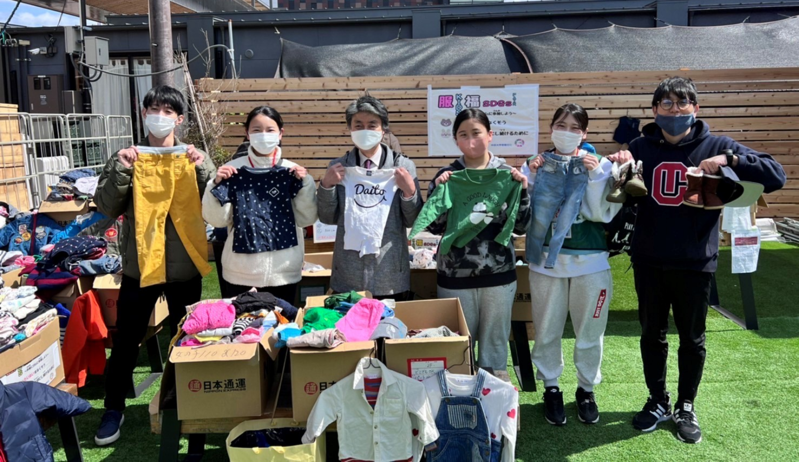 外で洋服を持つ6人